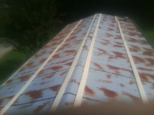 Rusted metal roof panels with new wood purlins before replacement — Storm Damage Roof Repair in Fishersville by Roofing Brothers