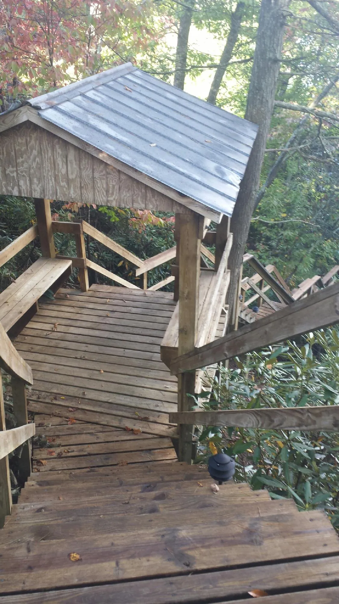 Metal roofed shelter over wooden steps on a wooded walkway — Skylight Repair & Installation work by our crew in Fishersville