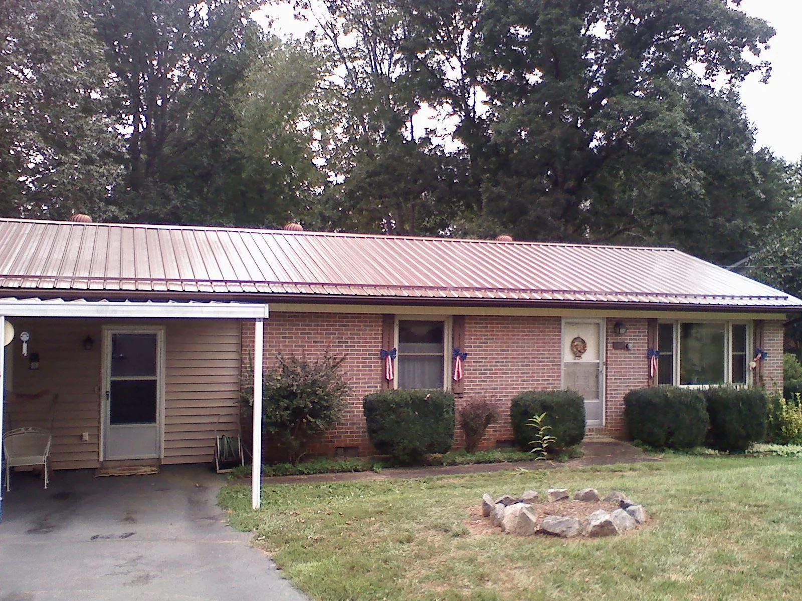 Bronze metal roof and carport on a brick ranch home — Roof Repair work by our crew in Fishersville